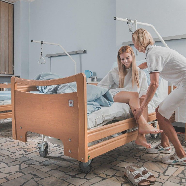 Vrouw helpt jonge zieke vrouw uit bed te komen in Amersfoort