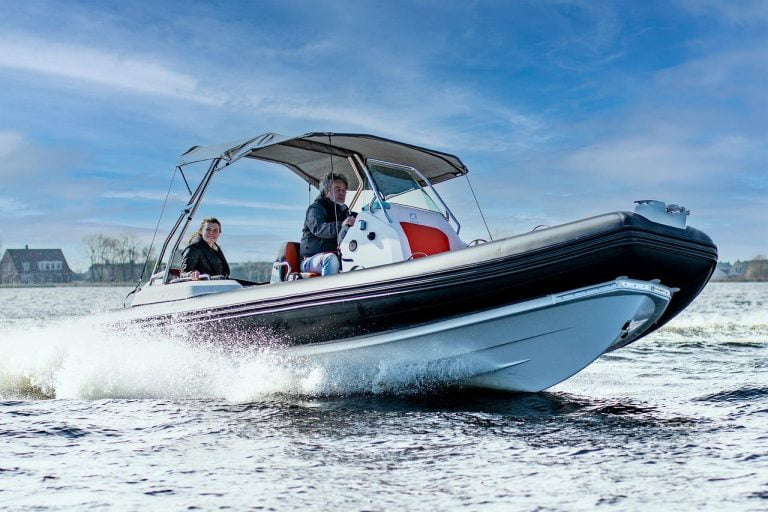 Een man bestuurt een boot en achter hem zit een vrouw in Amersfoort