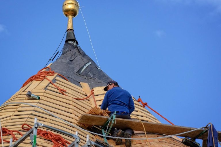 De technicus zit om het dak te leggen in Amersfoort
